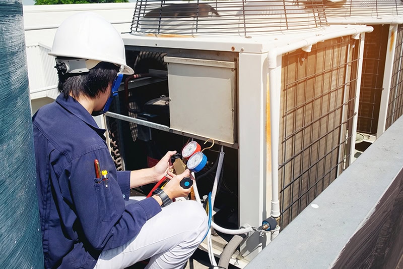 Commercial HVAC technician on the roof performing maintenance.